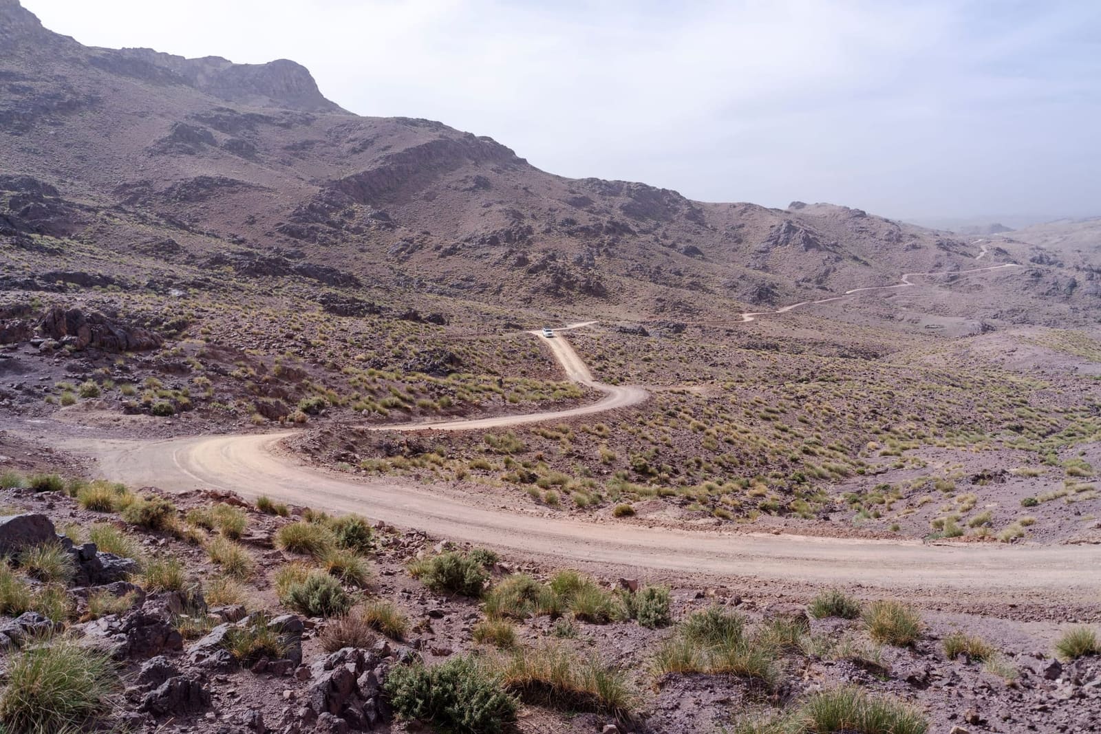 A dirt road winding through the arid Moroccan landscape
