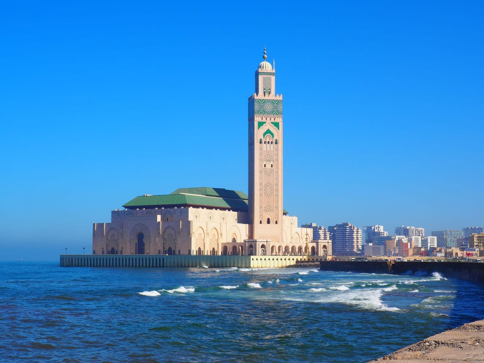 The minaret of the Hassan II Mosque against a blue Casablanca sky