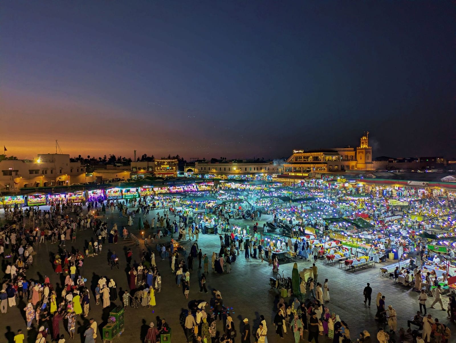 Food stalls lighting up at dusk on Jemaa el-Fnaa in Marrakech