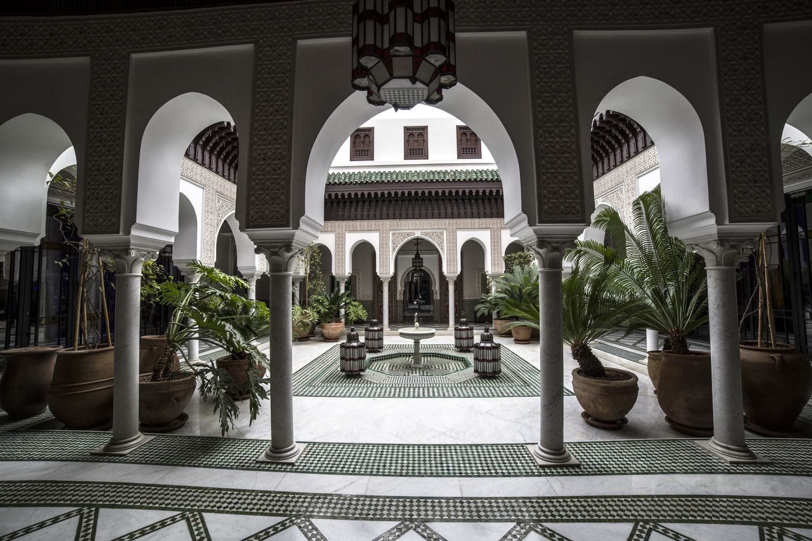 Fliesenkunst und ein Brunnen im Innenhof eines Riads in Marrakesch