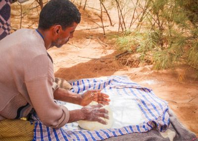 Herstellung von Fladenbrot in der Sahara-Wüste auf einem Leinentuch